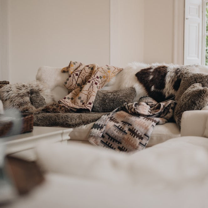 pile of sheepskin rugs, cushions and throws