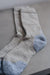 Close up view of beige and blue merino wool socks on a neutral background