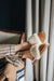 Women wearing Veronica Sheepskin Slippers in Mel whilst laying on a couch wearing striped pyjamas