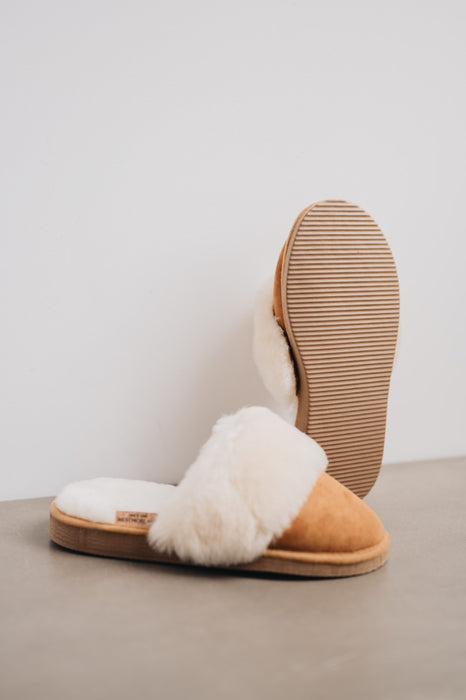 Veronica Mel Sheepskin Slippers showing the bottom of the EVA sole on a Concrete Surface