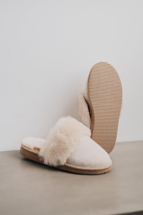 Veronica Vanilla Sheepskin Slippers showing the bottom of the EVA sole on a Concrete Surface
