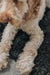 Close up of a dogs paws laid on a black smoke coloured sheepskin pet bed