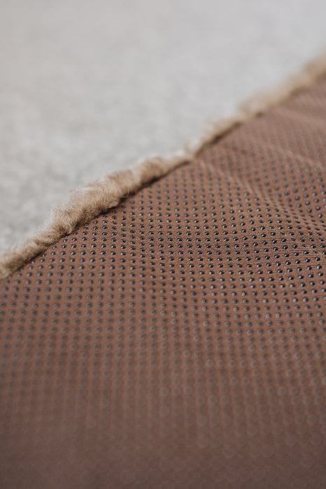 Close-up of a the rubber non
-slip underside of a sheepskin pet bed