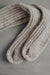 Ribbed beige natural merino wool sock on a light grey background - detail of ribbed sock and toe post