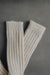 Ribbed natural merino wool sock on a light grey background - detail of ribbed sock neck