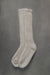 Ribbed beige natural merino wool sock on a light grey background.