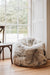 Beautiful natural melange bean bag chair in a room with large windows and wooden flooring.
