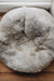 Birdseye view of a natural Melange sheepskin beanbag on a wooden floor