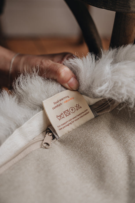 Close-up of a natural cotton HEATONS label on the bottom of a melange sheepskin bean bag.