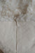 Close-up of the reverse of a white designer sheepskin rug, showing the seams between the square sections