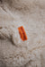Orange cotton label with 'Heatons' branding on an oatmeal sheepskin beanbag.