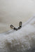 Close-up of a zipper on a textured white surface that is the bottom of a sheepskin beanbag.