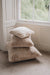 Stack of sheepskin cushion in a room with a window in the background