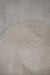 Close-up of a textured light fabric with a honeycomb pattern on the back / underside of a white sheepskin rug