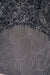 Close-up of a textured dark fabric with a honeycomb pattern on the back / underside of a grey / black sheepskin rug