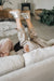 Lady wearing Erin Sheepskin Slippers falling back on a couch