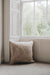 Oatmeal sheepskin floor cushion on a floor in a room with a large window