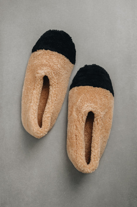 Birds eye view of ballerina style curly beige sheepskin slipper with black toe point