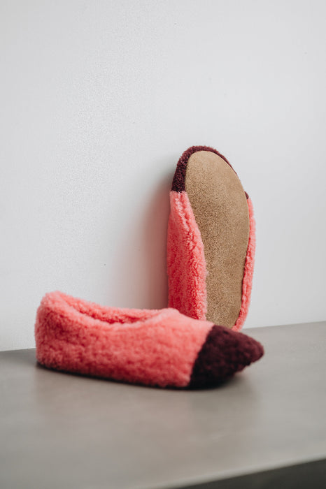 Bottom view of the soft suede sole of this ballerina style curly pink sheepskin slipper with burgundy toe point