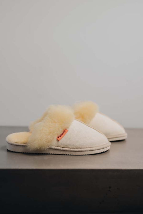 Side View of Gwen Eco Sheepskin Slippers on Concrete Surface
