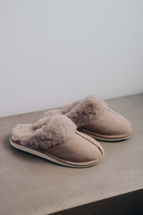 Side View of Gwen Stone Sheepskin Slippers on Concrete Surface