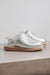 Side View of Cadi Silver Sheepskin Slippers on Concrete Surface