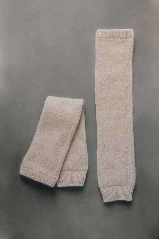 Pair of beige knitted wool leg warmers on a gray background- 