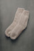 Pair of beige wool grip socks or bed socks on a gray background