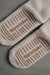 Beige wool slippers socks with 'WarmSoles' branding on a gray background