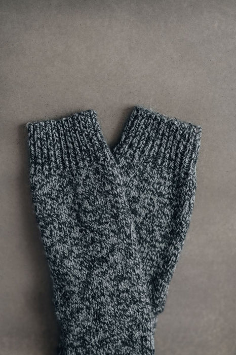 Pair of gray knitted wool bed socks on a gray background