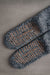 Pair of blue slipper socks with brown sole pattern on a gray back ground - WarmSoles 