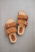 Birds eye view of the sandals and their metal buckles and sheepskin straps