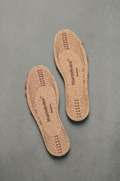 Pair of brown sheepskin insoles with 'WarmSoles' branding on a gray background