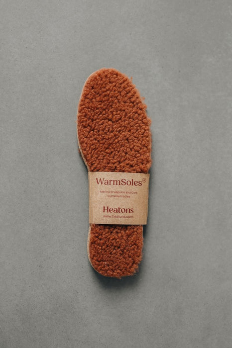 Brown curly Sheepskin  insoles with WarmSoles label on a gray background