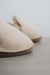 Close up of vanilla sheepskin slippers on a stone surface