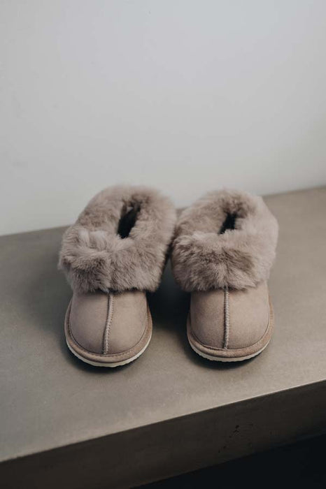 Front View of Ruby Stone Sheepskin Slippers on Concrete Surface