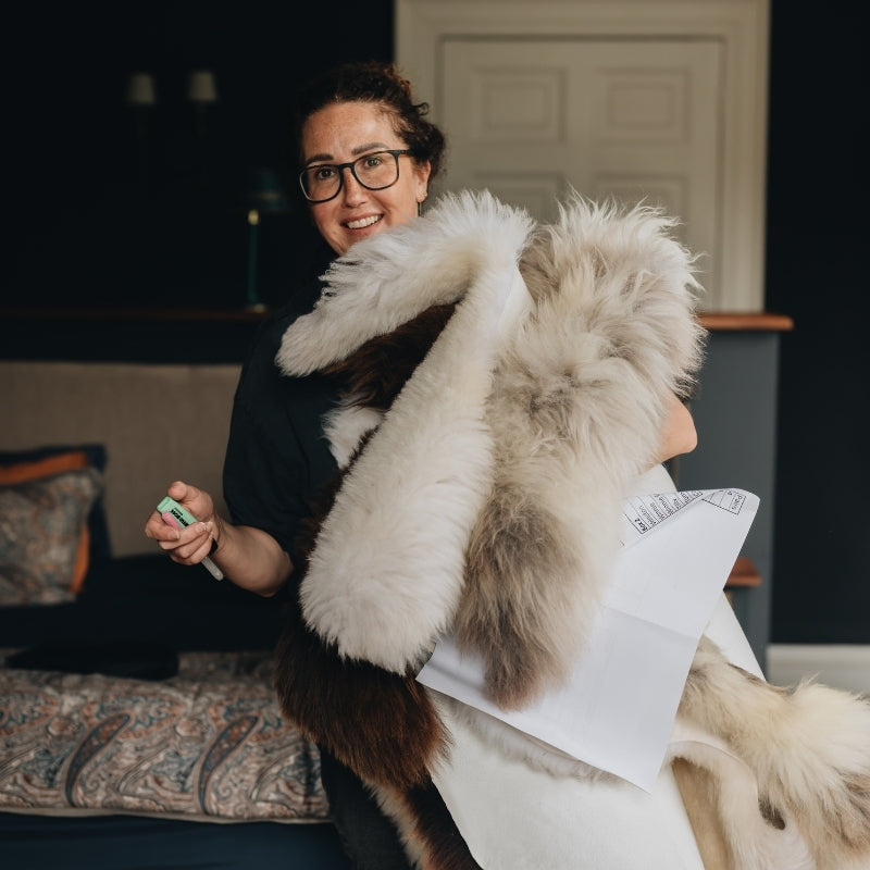 Person holding a sheepskin rugswith a blurred background