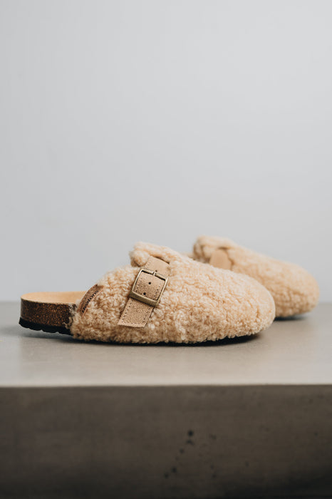 Side view of curly sheepskin mule with sheep skin strap and metal buckle