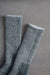 Pair of grey and black merino wool walking socks on a grey background