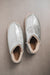 Birds Eye View of Cadi Silver Sheepskin Slippers on Concrete Surface