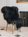A deep black/brown Icelandic Sheepskin Long Wool Rug. Draped over a brown wooden chair.