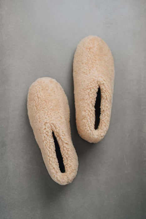 Birds eye view of a camel coloured curly merino sheepskin boot slipper.
