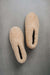 Birds eye view of a camel coloured curly merino sheepskin boot slipper.
