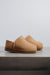Side View of Cadi Mel Sheepskin Slippers on Concrete Surface