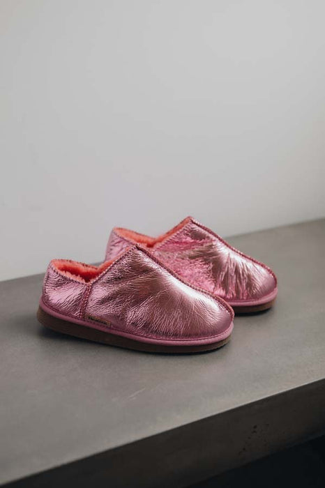 Side View of Cadi Metallic Pink Sheepskin Slippers on Concrete Surface