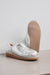 Cadi Silver Sheepskin Slippers showing the bottom of the EVA sole on a Concrete Surface