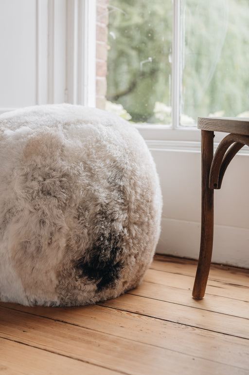 close up of an icelandic sheepskin footstool/pouffe in a melange grey, white and beige colouration