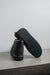 Dark brown Erin women's sheepskin slippers with black soles on a light gray surface and white background