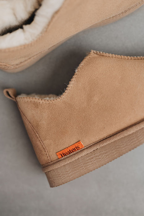 Close up of Tan coloured ankle-high sheepskin slipper with orange cork label showing the Heatons brand