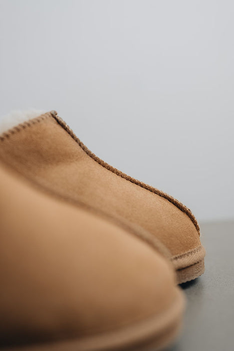 Close up of the toe post of a pair of tan coloured ankle-high sheepskin slipper (Henry)